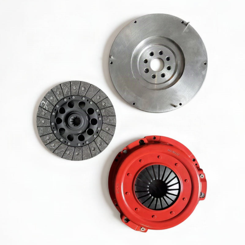 A set of three automotive clutch components, including a silver steel flywheel, a dark gray friction plate, and a bright red pressure plate, arranged on a plain white background.