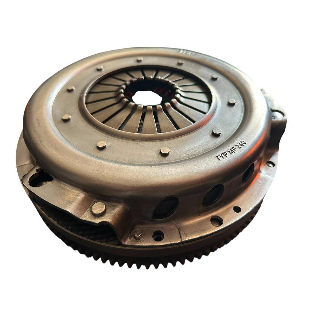 A metallic clutch pressure plate assembly with a ribbed metal flywheel and visible stamped part number 'TNP-MP-243' on the outer ring, isolated on a black background.